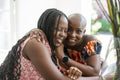 Smiling mother and teenage daughter embracing at table