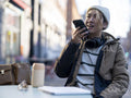 Man using smart phone while sitting at sidewalk cafe