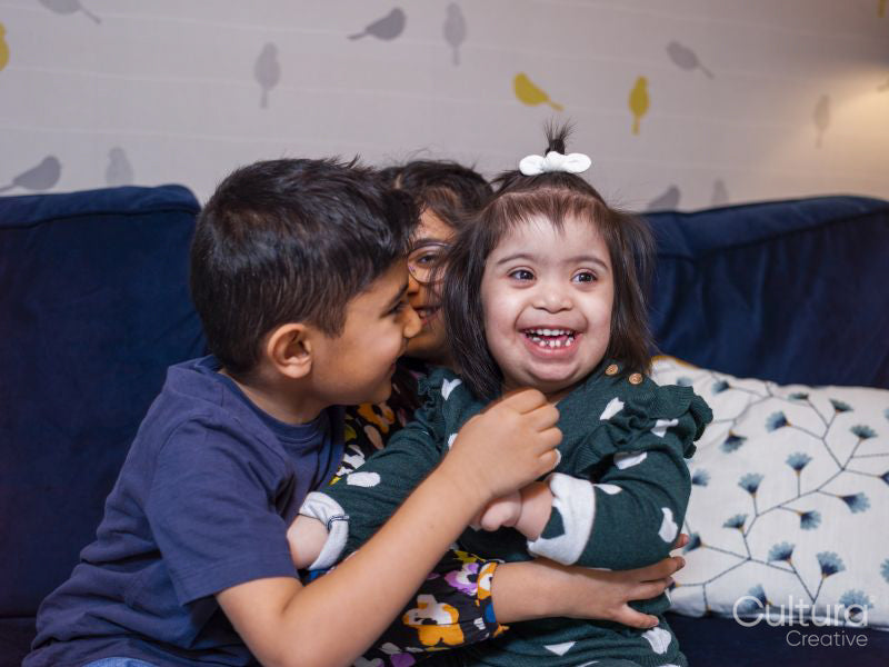 Smiling siblings sitting on sofa