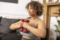 Woman exercising with dumbbells in living room