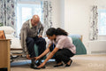 Nurse helping senior man to get dressed at nursing home