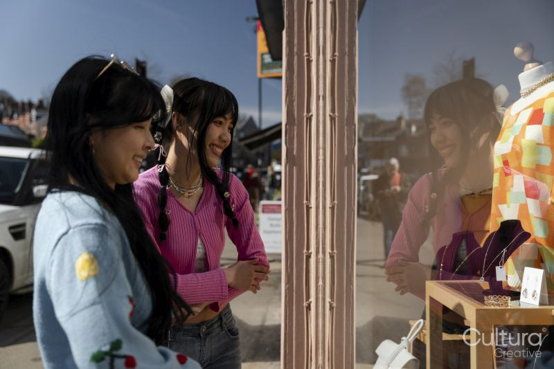 Smiling young women window shopping