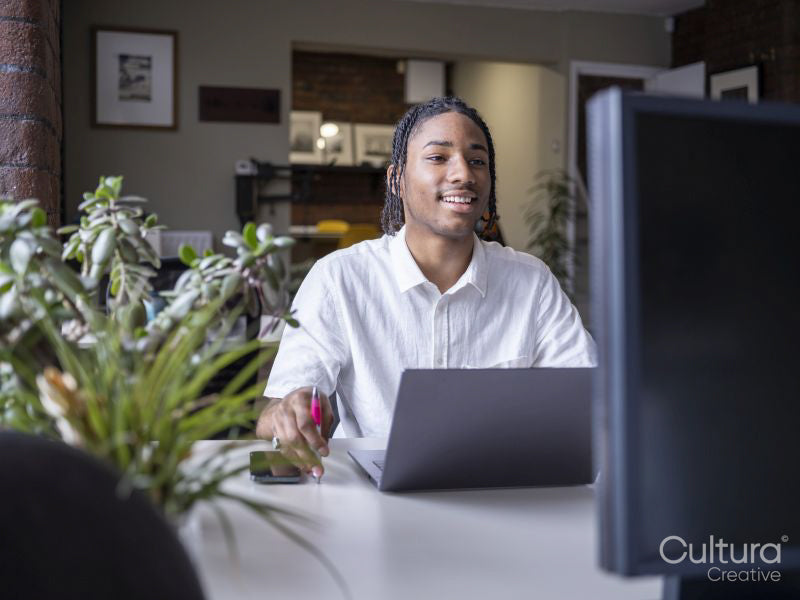 Teenage boy using laptop in office