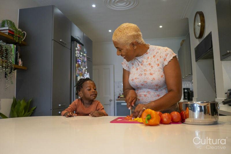 Mother and daughter preparing food in kitchen
