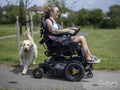 Woman in electric wheelchair going on walk with dog