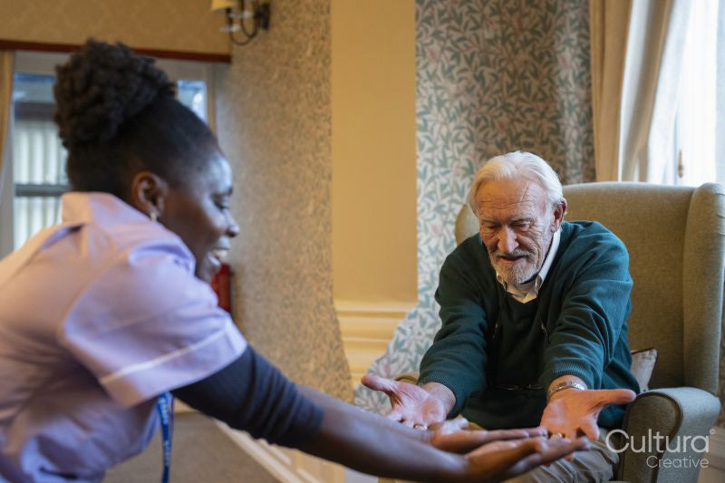 Senior man exercising with nurse in nursing home
