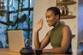 Smiling woman waving during video call on laptop