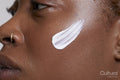 Close-up of woman with face cream on cheek