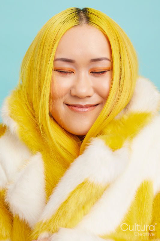 Smiling young woman with yellow hair, wearing fur coat