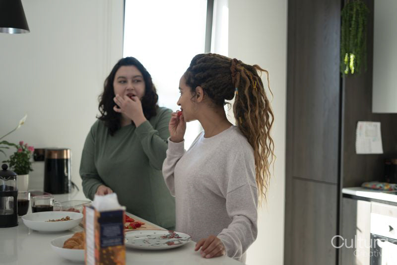 Two women preparing meal in kitchen