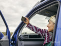 Woman sitting in van and taking selfie