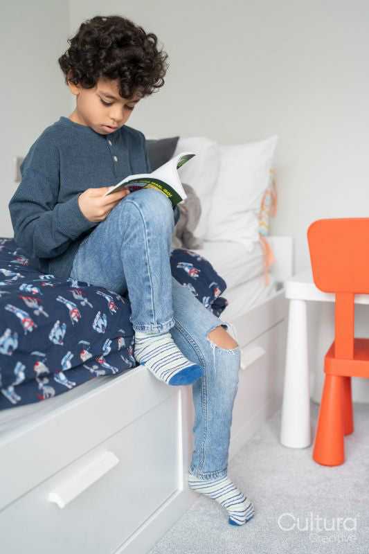 Boy sitting on bed and reading book