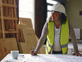Woman in hardhat looking at blueprint