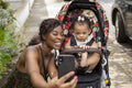 Mother taking selfie with baby daughter in stroller