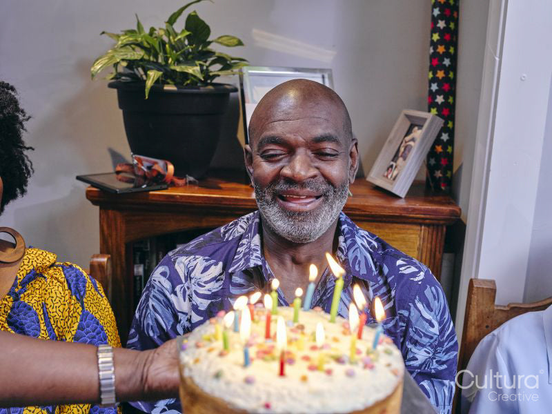 Smiling man looking at birthday cake