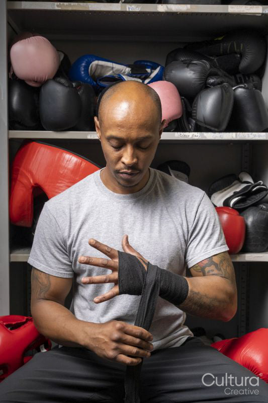 Mature man wrapping hands for boxing match