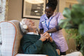 Smiling senior man and female nurse interacting in nursing home