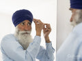 Senior man wrapping turban around head