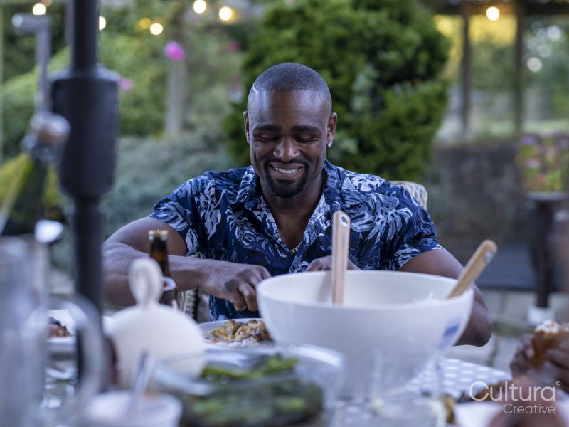 Smiling man eating dinner outdoors