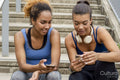 Sporty female friends using phones