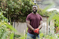 Portrait of smiling man standing in urban vegetable garden