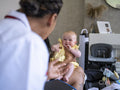 Nurse visiting woman with baby girl at their home