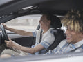 Smiling male couple driving car