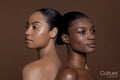 Young women standing back to back
