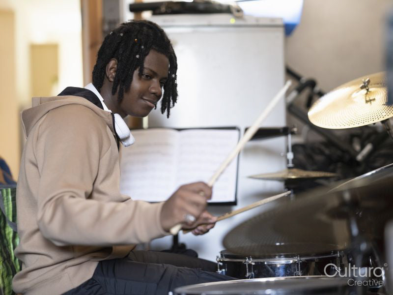 Teenage boy practicing playing drums