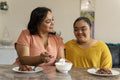 Mother eating dinner with down syndrome daughter at home