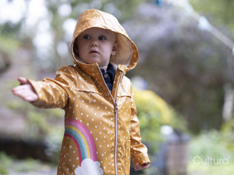 Girl in raincoat standing in rain