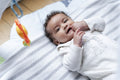 Baby girl lying on play mat at home