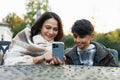Mother and son sitting with phone outside of nursing home