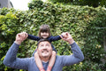 Smiling father carrying daughter on shoulders outdoors