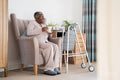 Smiling senior woman sitting in armchair, holding mug