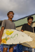 Smiling surfers standing with surfboards