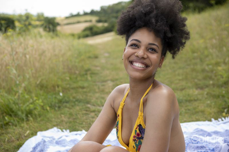 Portrait of young woman relaxing on blanket in meadow