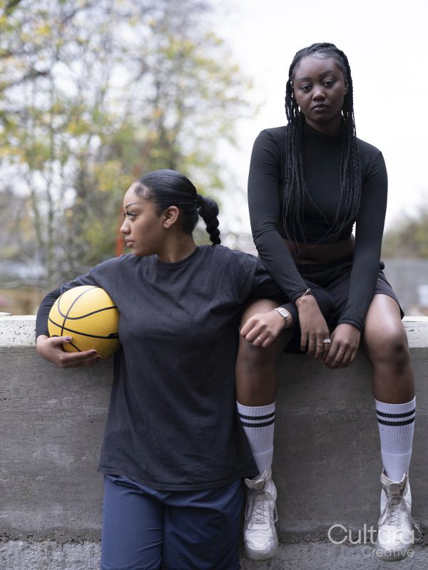 Two female friends outdoors holding basketball ball