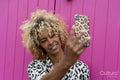 Woman taking selfie against pink wall
