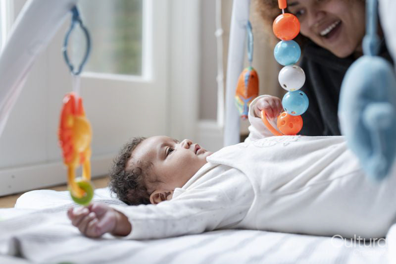 Mother playing with baby daughter at home