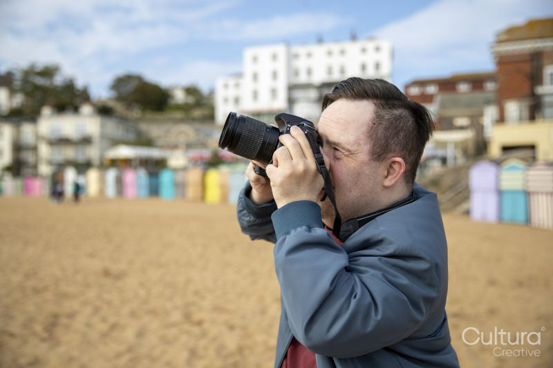 Mid adult man taking pictures on beach