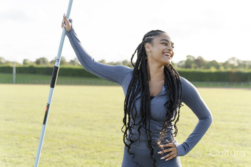 Portrait of confident female athlete holding javelin
