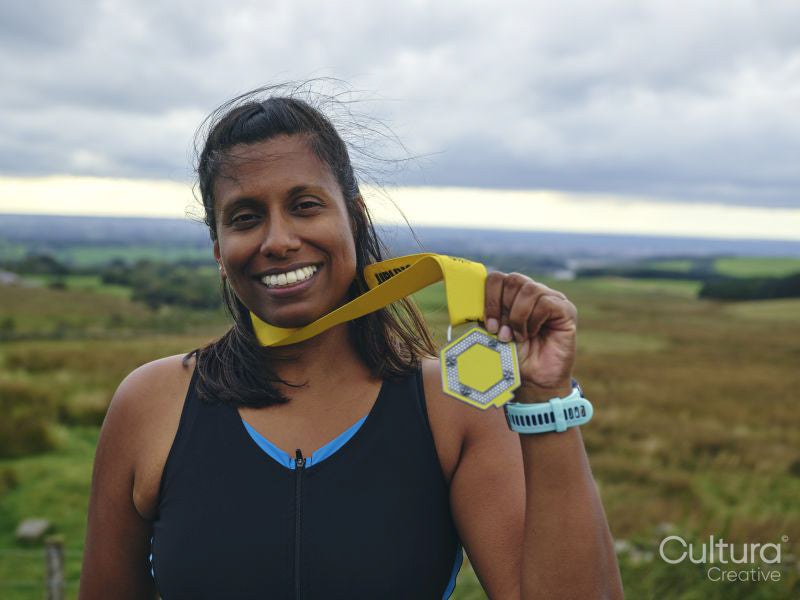Portrait of smiling female athlete holding medal