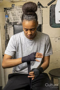 Young woman wrapping hands for boxing match
