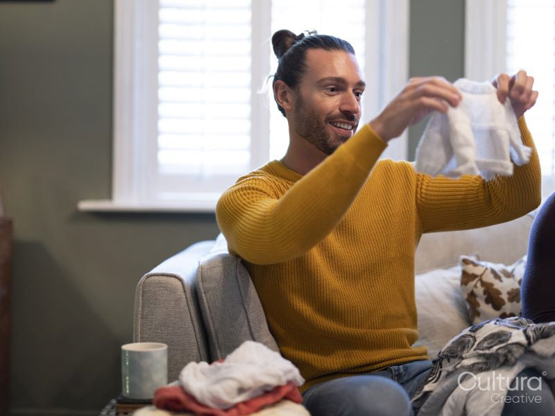 Man looking at baby clothing