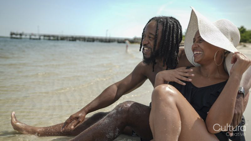 Smiling couple sitting on beach