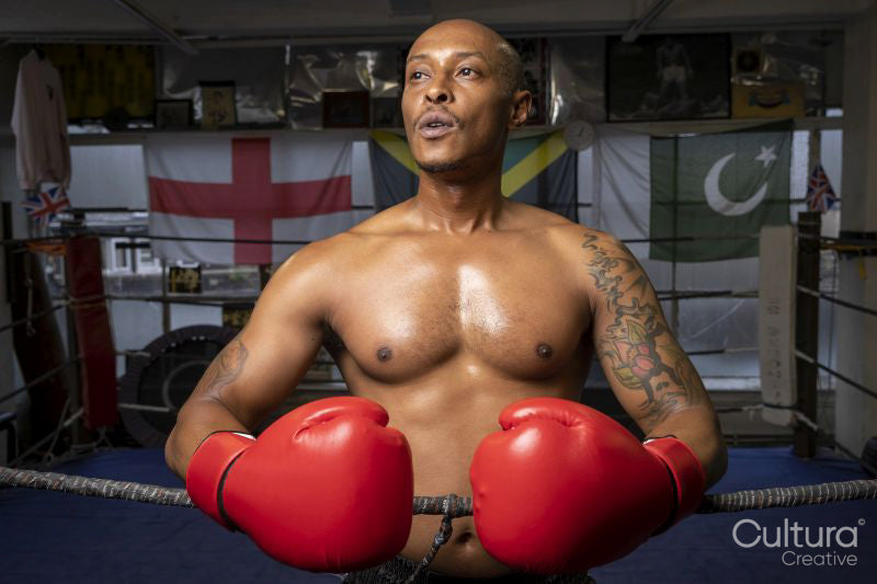 Mature man wearing boxing gloves in boxing ring