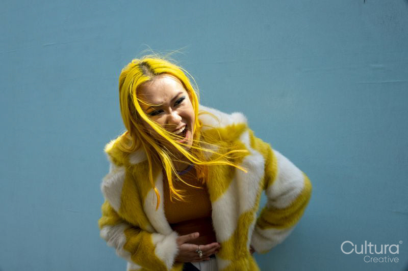 Young woman with yellow hair laughing outdoors