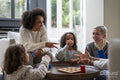 Happy family playing rock paper scissors at home