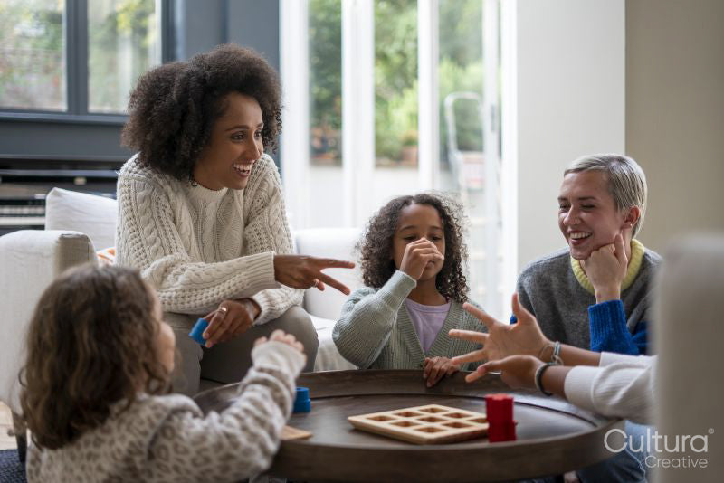 Happy family playing rock paper scissors at home
